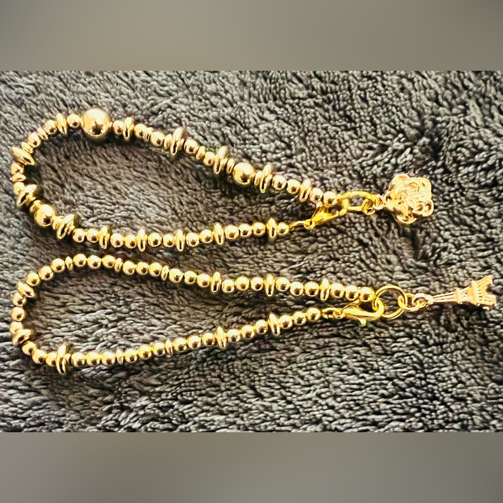 Two gold pendent bracelets.